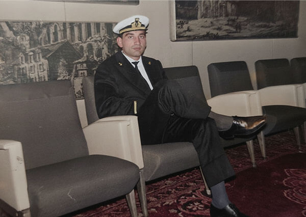 Vittorio Russo in uniforme da terzo ufficiale di marina seduto in un salone a bordo della nave Venezuela.